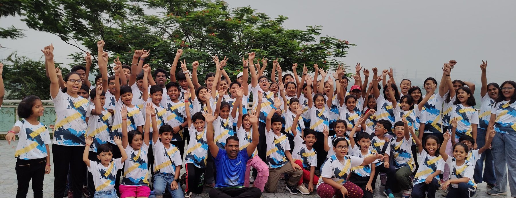 A full cohort of participants celebrating with their arms raised after finishing the eight-week challenge